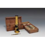 A late 19th Century lacquered brass student's field monocular microscope, within a mahogany case,