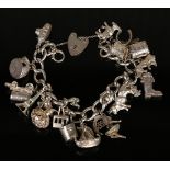 A silver curblink charm bracelet, fitted with a variety of mostly silver charms, including a bull,