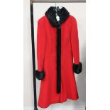 A mid/late 20th Century red wool lady's winter coat with black fur effect trim, bearing label marked