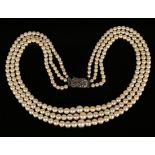 A three row necklace of graduated cultured pearls on a sterling and marcasite set clasp.