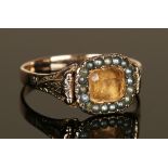 A Victorian seed pearl and yellow gem set cluster ring, decorated with engraved scrolling shoulders,
