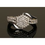 A white gold and diamond set hexagonal cluster ring with diamond set two row shoulders, mounted with