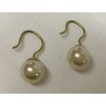 A pair of faux pearl earrings on 9ct gold wires.