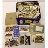 A tin containing a large quantity of cigarette cards to include football.