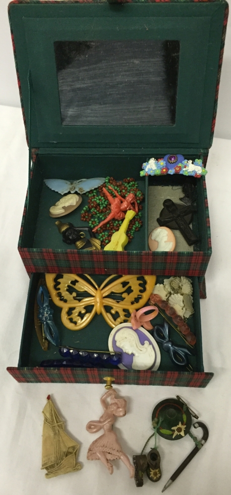 A tartan jewellery box containing some early plastic brooches, hair accessories, necklaces etc.