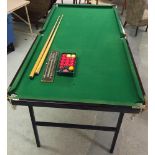 Snooker table complete with set of balls, cues and scoreboard.