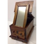 A vintage wooden jewellery box with flip-up mirror.