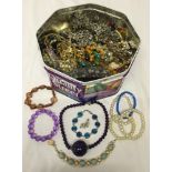 A large tin of vintage and modern costume jewellery, including pendants, bracelets and glass bead