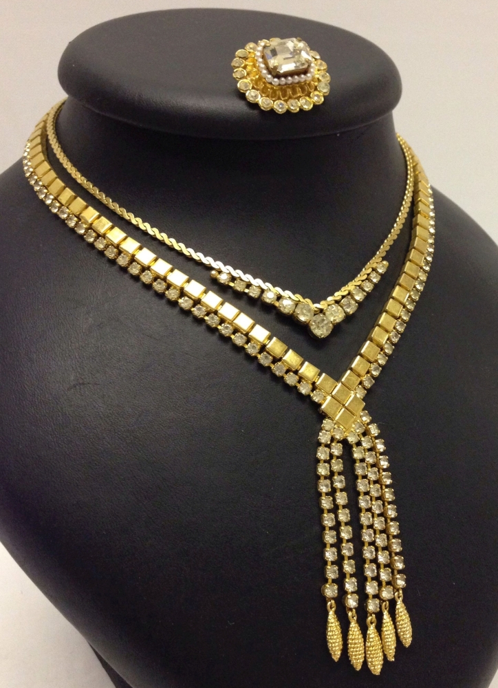 2 goldtone and diamante necklaces together with a matching brooch.