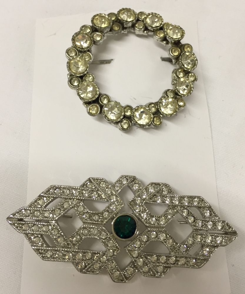 2 diamante costume jewellery brooches, one in an Art Deco design with central green stone.