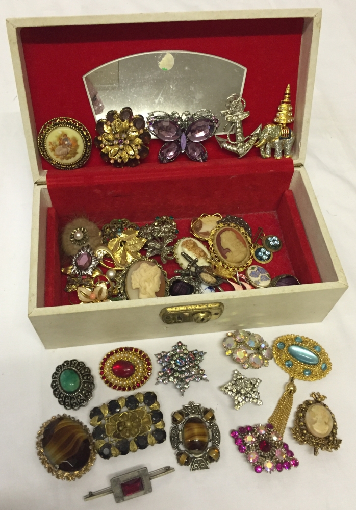 Cream jewellery box containing a good quantity of vintage brooches.