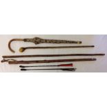 3 wooden walking sticks together with 2 riding crops a wooden handled umbrella.