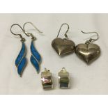3 pairs of silver earrings. One with hearts, one with abalone shell decoration and one with blue