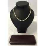 A cased single strand of cultured pearls necklace, 24" long with white metal clasp set with an