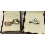 3 pretty silver rings. One set with a cluster of white stones, one with pink & white stones and