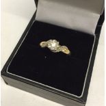 A 9ct gold solitaire diamond ring with decorative shoulders containing 4 small diamonds and a