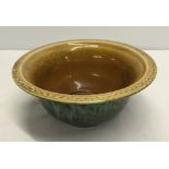 A Holkham pottery green glazed bowl with light brown interior.