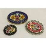 3 oval micro mosaic brooches with floral designs on a red, black and dark blue backgrounds.