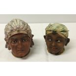 2 bisque porcelain tobacco jars in the shape of heads. One is an African child, the other is an