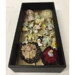 A box of 17 vintage bisque half dolls and head/shoulder dolls, and a powder puff pin doll base.