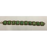 An Art Deco costume jewellery bracelet comprising of 10 linked panels each set with green stones (