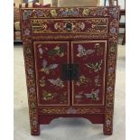 A reproduction Chinese 2 door small cabinet with butterfly painted decoration over red ground. 40