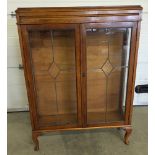 A 2 shelf oak display cabinet with leaded glass doors 125cm tall, 94cm wide & 17cm deep.