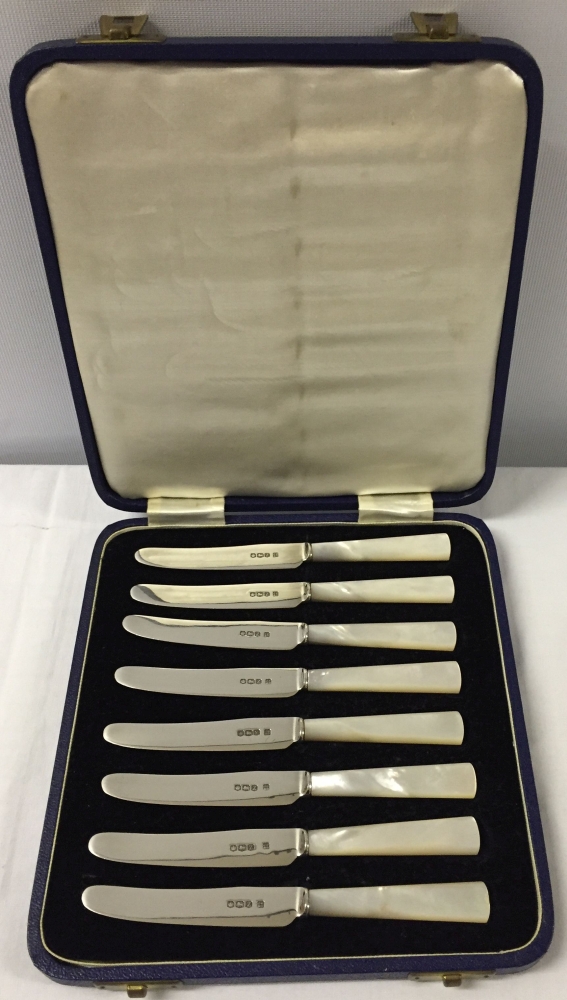 A cased set of 8 silver butter knives with mother of pearls handles