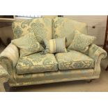 A reproduction Victorian 2 seater sofa in cream & blue damask upholstery with wooden & brass legs,