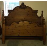 A pine bed 5' 6" wide with carved head and footboards.