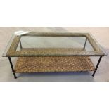 A glass topped cane conservatory coffee table. 124 x 64cm.