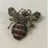 A silver bee brooch set with marcasite and garnets. Approx 2.5cm x 2.5cm