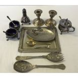 A box of mixed silver plate items and a pair of hallmarked silver candle holders.