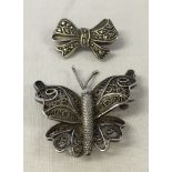 2 pretty brooches, 1 in the shape of a butterfly with filligree work and the other a bow set with