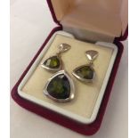 A boxed set of silver triangular shaped earrings set with olive green stones with matching