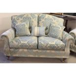 A reproduction Victorian 2 seater sofa in cream & blue damask upholstery with wooden & brass legs,