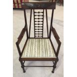 An early 20th century unusual ladder back chair with carved wing decoration to back.