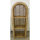 A rattan 3 shelf unit with curved top.