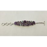 A heavy silver bracelet set with amethyst, blue topaz, & marbled stone stones (boxed).