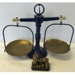 A pair of blue kitchen scales with brass weights.