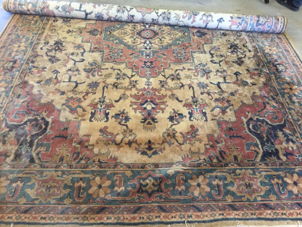 A very large gold patterned rug approx 340 x 270cm