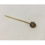 A Victorian 13K gold stick pin set with a single diamond.