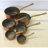 A set of 6 graduated brass handled copper pans.