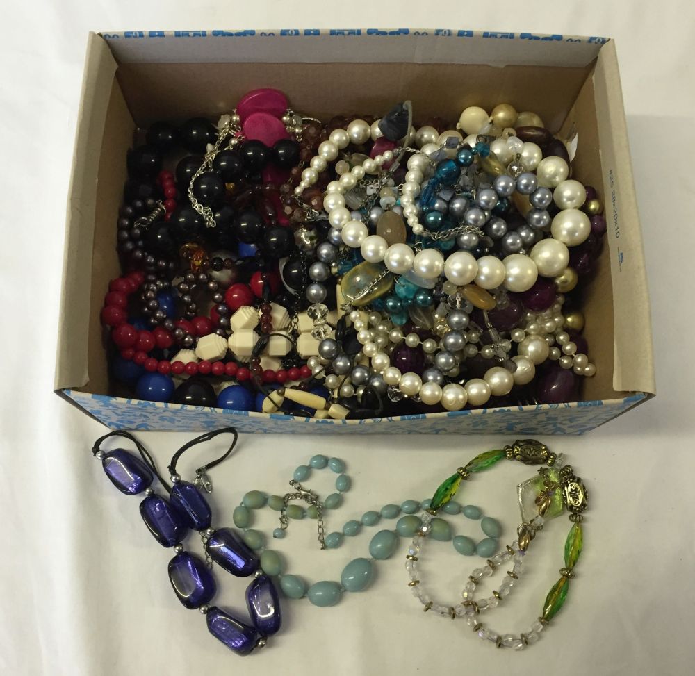 A box containing a large quantity of costume jewellery necklaces.