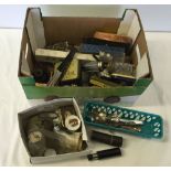 A box of assorted items to include vintage tins and a small cased telescope.