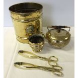 5 brass items consisting of a bucket with lion head handles, 2 pairs of fire tongs, a kettle and a