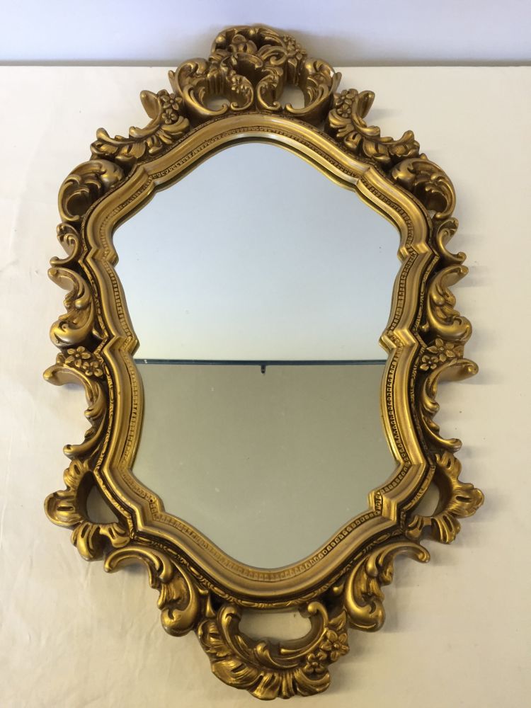 A gilt framed ornate mirror, 72cm x 42cm.