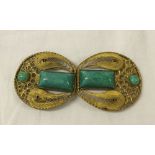 A vintage figure belt buckle set with turquoise.