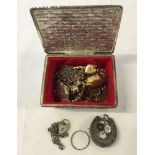 A small white metal trinket box containing jewellery items including a Victorian silver horseshoe