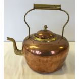 A large copper kettle with brass handle & spout.